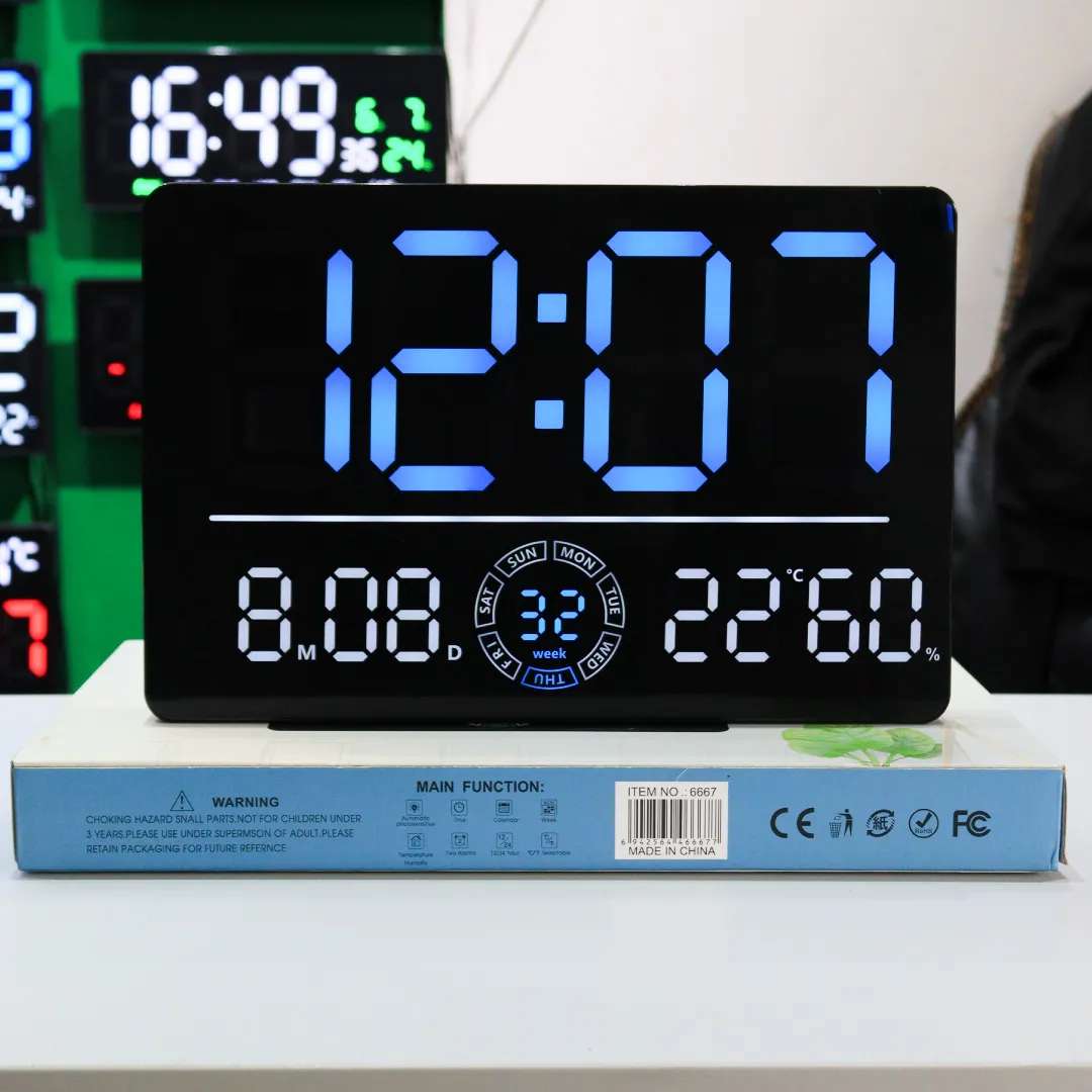 Wall Secrets 6667 LED clock in blue display mode placed on packaging, showing time, date, weekday ring, temperature, and humidity