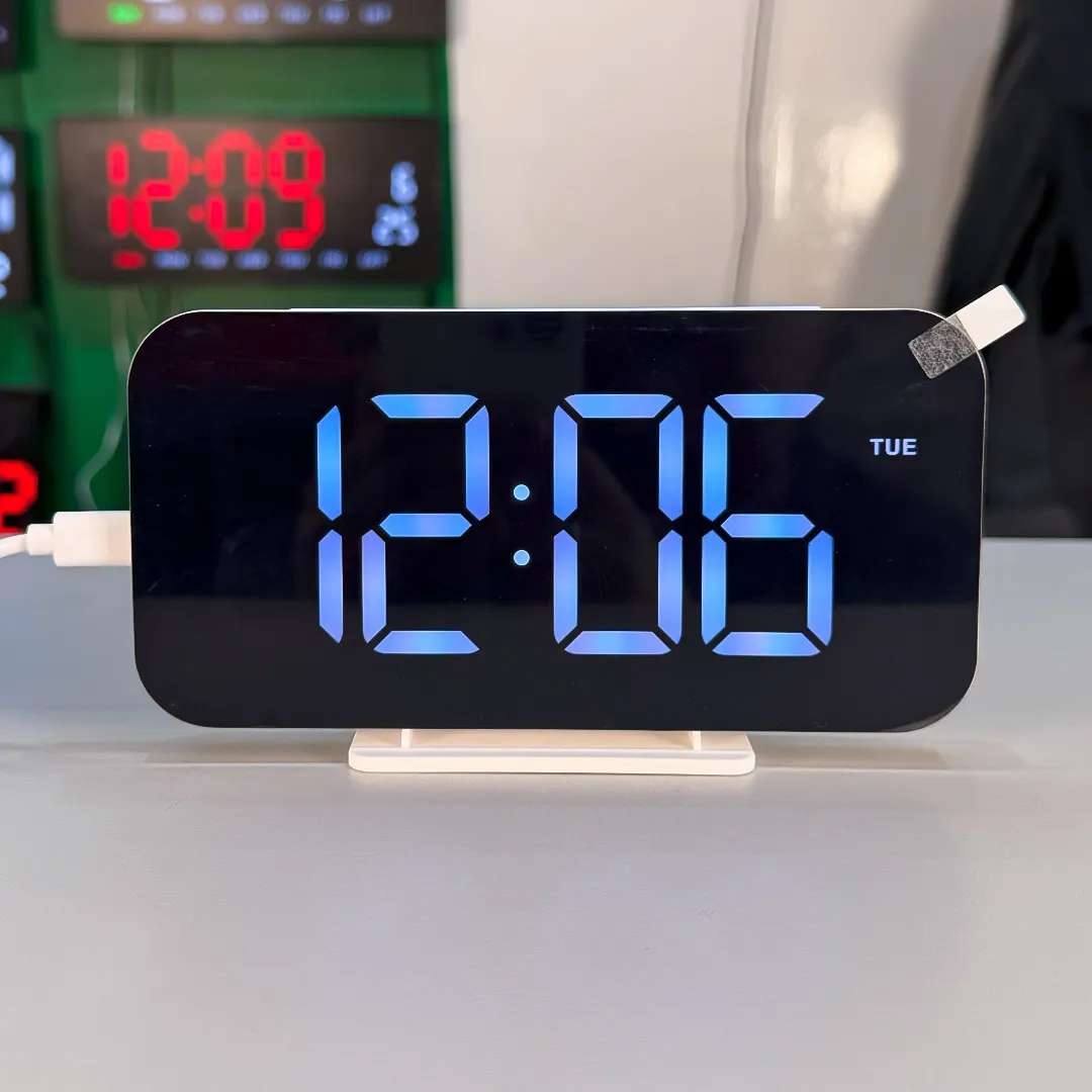 Smart mirror LED clock with blue time display and day indicator on desk